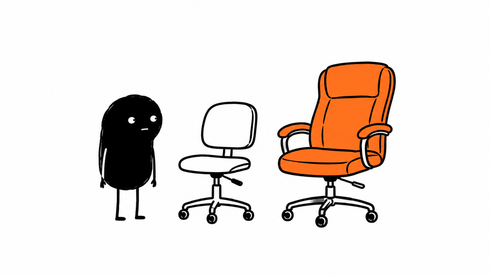 Lev stands between his small chair and a slightly grander orange chair, sitting in neither.