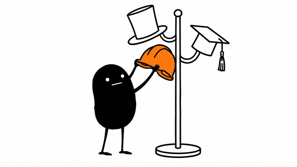 Lev lifts an orange hard hat off a stand that also holds a top hat and a mortarboard.