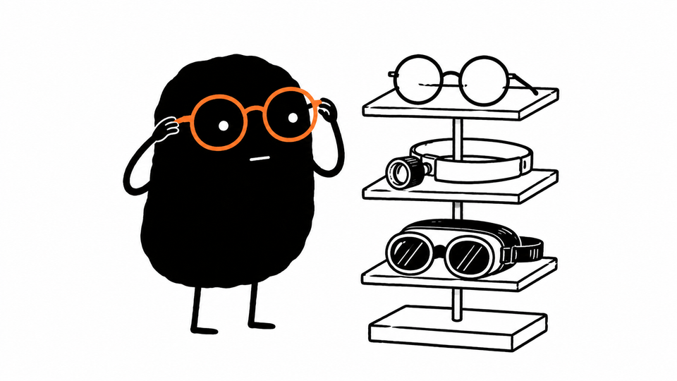 Lev tries on an orange pair of round glasses from a stand of three very different pairs.